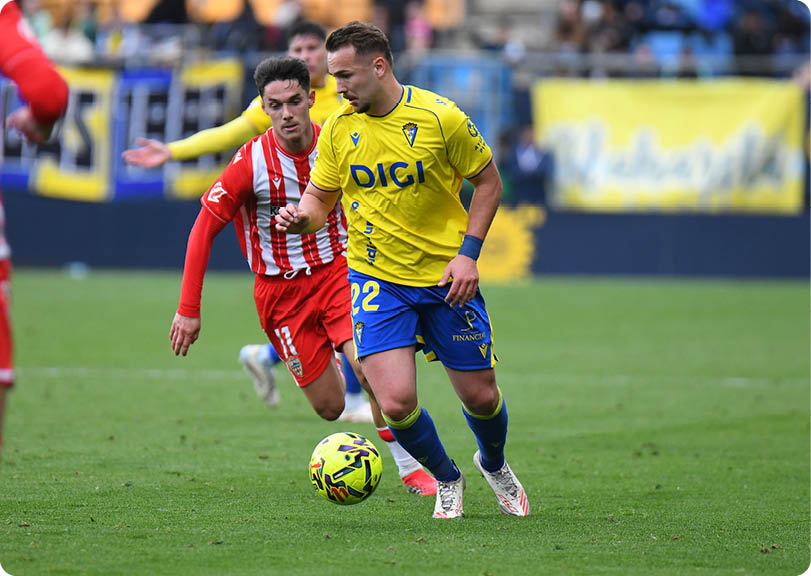 Soccer players on a field with one player in a red jersey and another in a yellow jersey. Contenido generado con IA