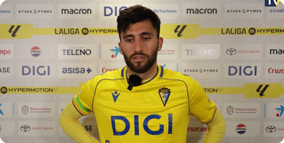 A man wearing a yellow shirt and a microphone stands in front of a backdrop with a Digic logo. Contenido generado con IA