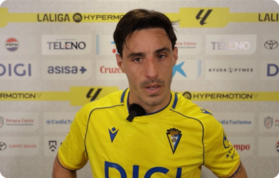 A man wearing a yellow shirt is standing in front of a yellow and white backdrop. Contenido generado con IA