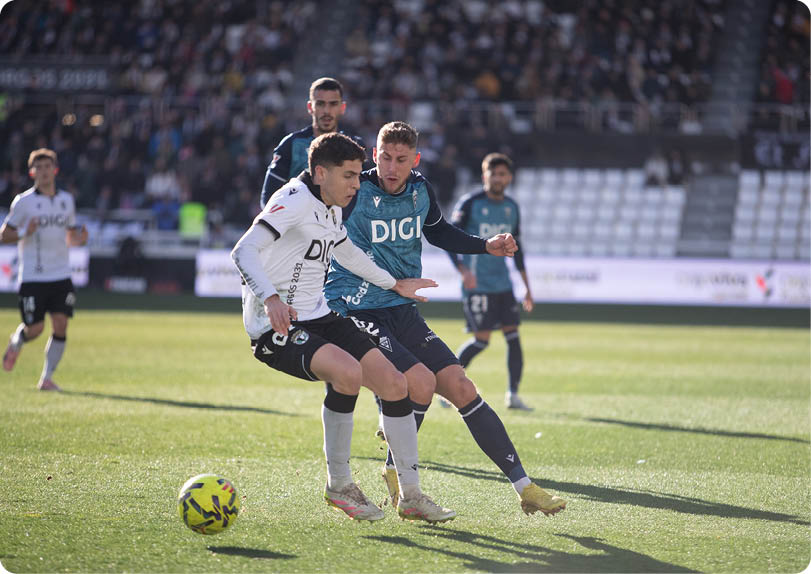 Soccer players on a field, one of them wearing a white shirt and black shorts. Contenido generado con IA