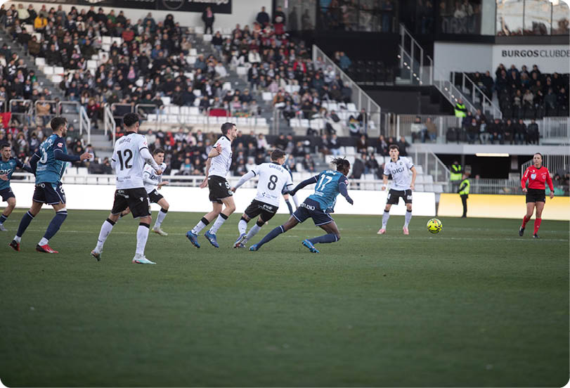 Soccer players on a field with a crowd watching. Contenido generado con IA