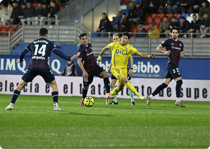 Soccer players on a field, one of them wearing a yellow shirt. Contenido generado con IA