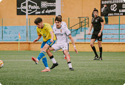Three men playing soccer on a field. One man is kicking the ball, while the other two are running towards him. Contenido generado con IA