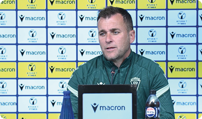 A man is sitting at a desk with a Macron sign in front of him. Contenido generado con IA