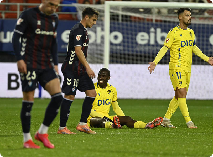 Soccer players on a field, one player is lying on the ground. Contenido generado con IA