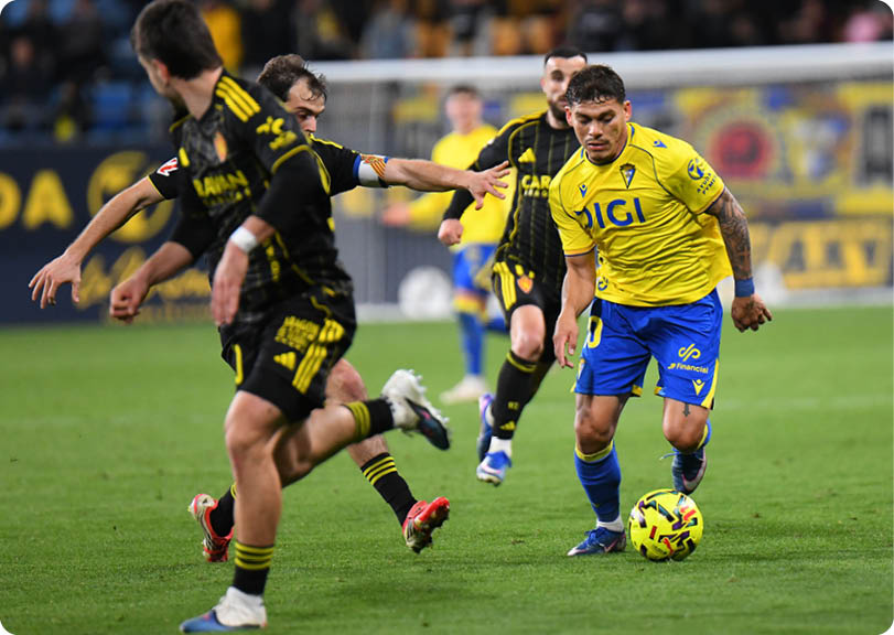 Soccer players on a field, one of them wearing a yellow shirt. Contenido generado con IA