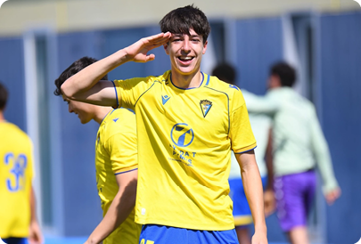 A man in a yellow shirt is waving with his hand in the air. Contenido generado con IA