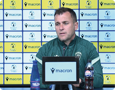 A man is sitting at a desk with a Macron sign in front of him. Contenido generado con IA