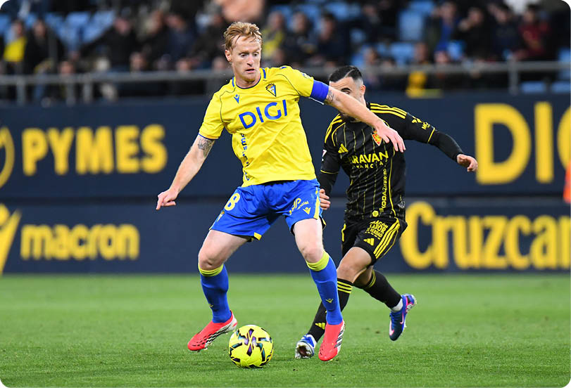 Soccer players on a field, one player is lying on the ground. Contenido generado con IA