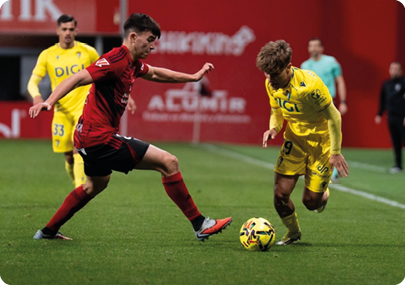 Two soccer players are playing against each other on a field. Contenido generado con IA