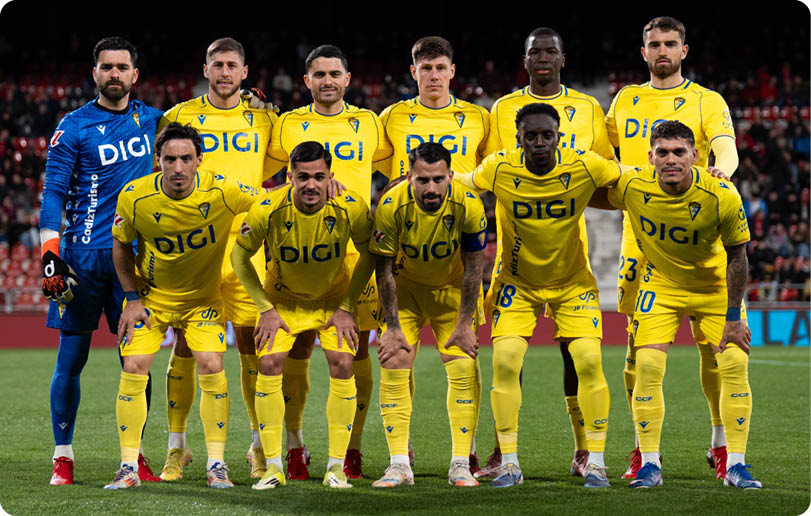 A group of men wearing yellow jerseys pose for a photo on a field. Contenido generado con IA