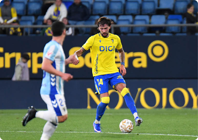 A soccer player in a yellow jersey is running on the field. Contenido generado con IA