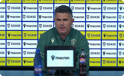 A man is sitting at a desk with a bottle of water and a can of soda in front of him. Contenido generado con IA