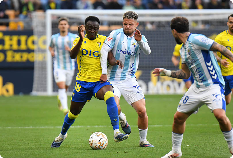 A soccer player in a yellow jersey stands on the field, looking up at the sky. Contenido generado con IA