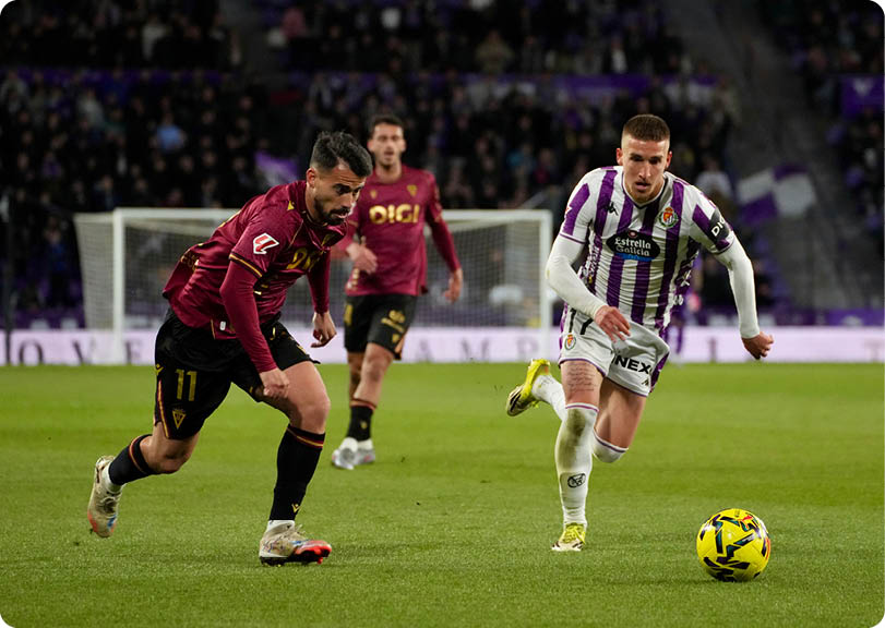 Two soccer players on a field. Descripci n generada con IA