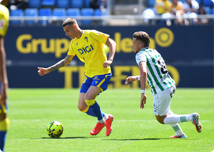 Two soccer players on a field. Descripci n generada con IA
