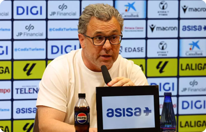 A man wearing glasses is sitting at a desk with a laptop in front of him. Descripci n generada con IA