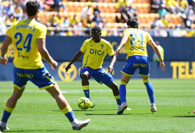 A soccer player wearing a red shirt and black shorts. Descripci n generada con IA