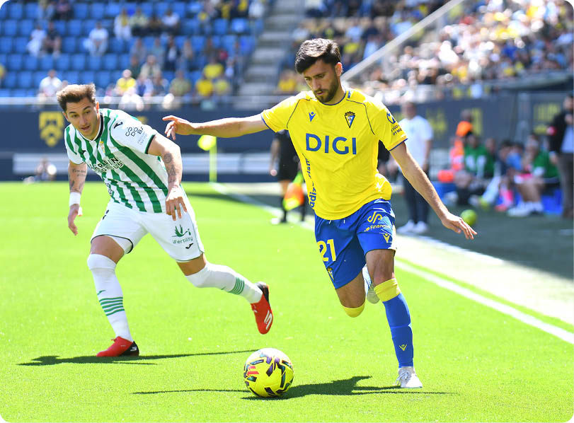 Two soccer players are playing on a field. Descripci n generada con IA