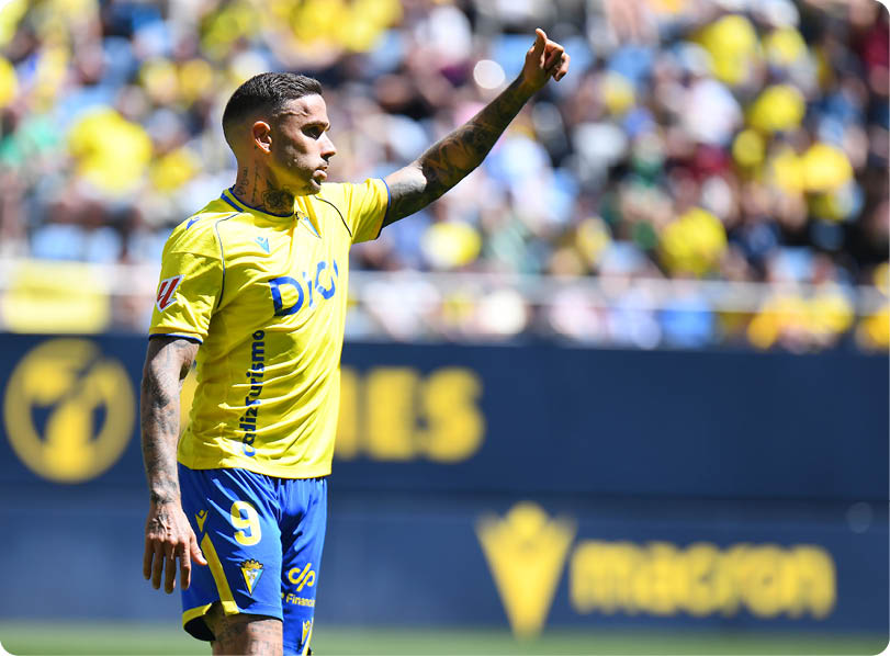 A soccer player wearing a yellow and blue shirt. Descripci n generada con IA