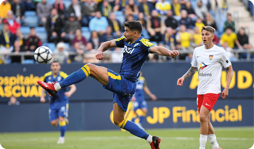 A soccer player in a blue uniform kicks a soccer ball. Descripci n generada con IA