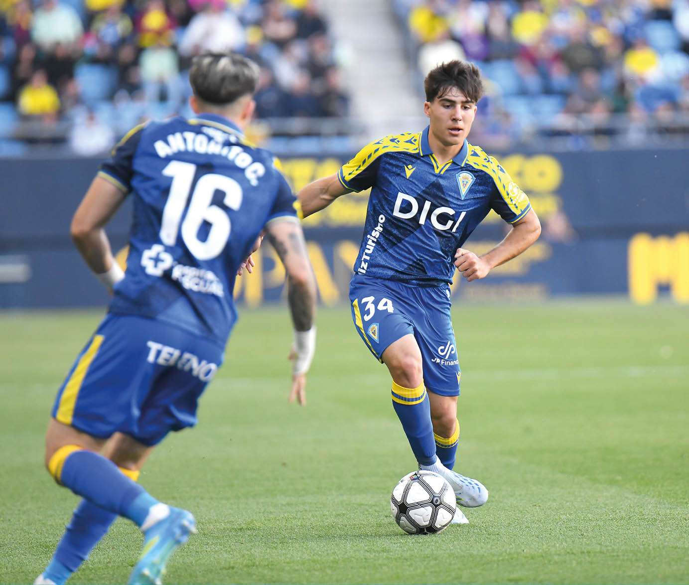 Two men playing soccer on a field. Descripci n generada con IA