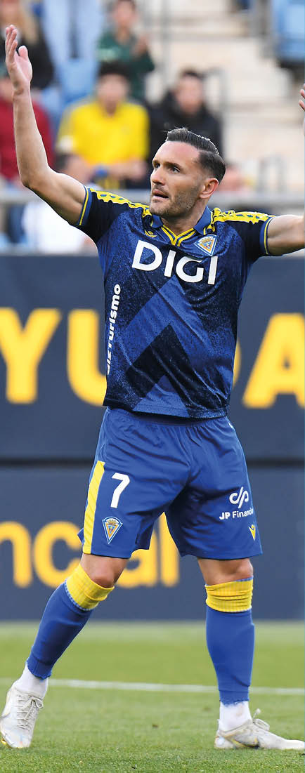 A soccer player wearing a blue and yellow jersey. Descripci n generada con IA