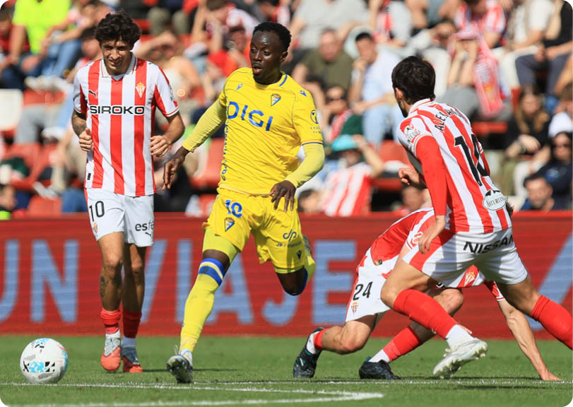 A soccer player in a yellow jersey is running towards the ball. Descripci n generada con IA
