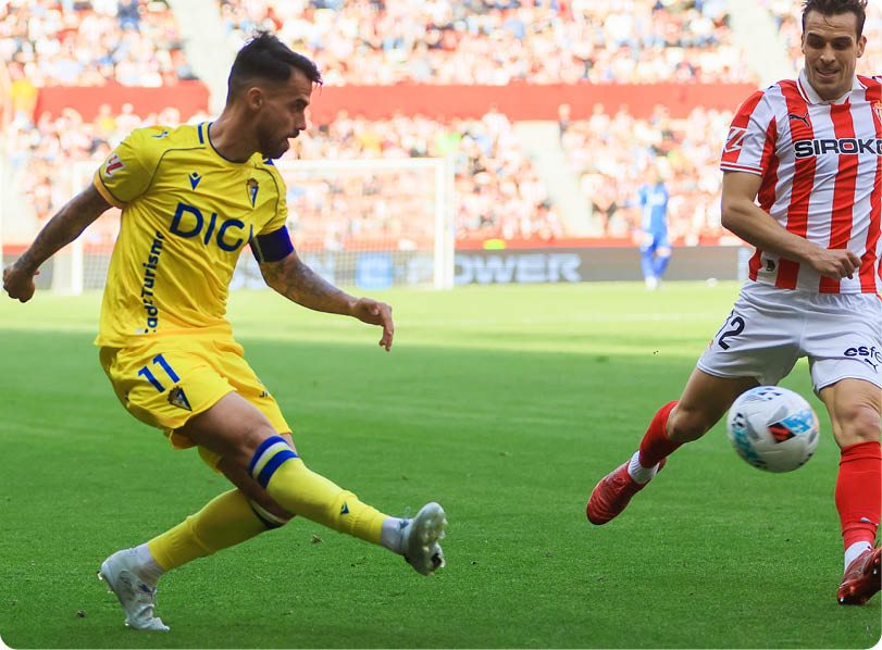 A soccer player in a yellow shirt is kicking the ball. Descripci n generada con IA