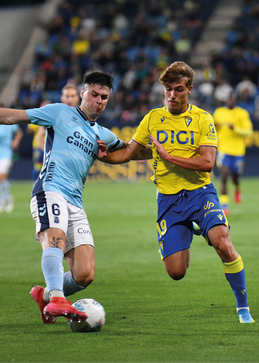 Two soccer players are playing on a field. Descripci n generada con IA