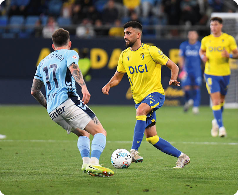 A soccer player in a yellow and blue uniform is about to kick the ball. Descripci n generada con IA