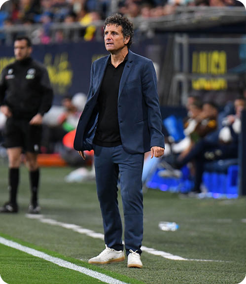 A man wearing a blue jacket and white shoes. Descripci n generada con IA