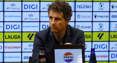A man sitting at a desk with a Pepsi bottle in front of him. Descripci n generada con IA
