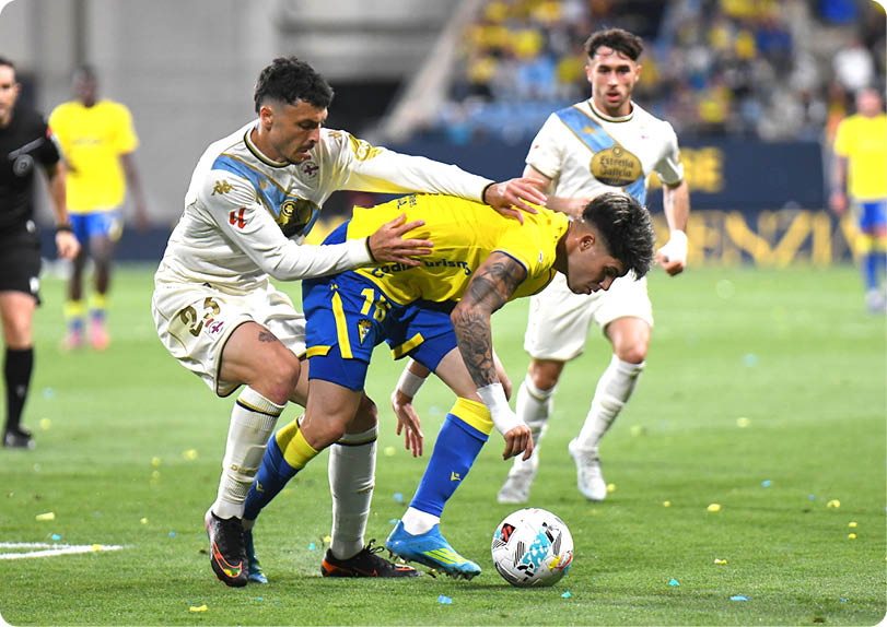 Two soccer players are fighting for the ball. Descripci n generada con IA