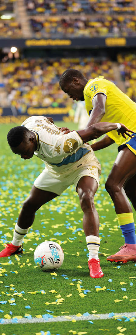 Two soccer players are fighting for the ball. Descripci n generada con IA