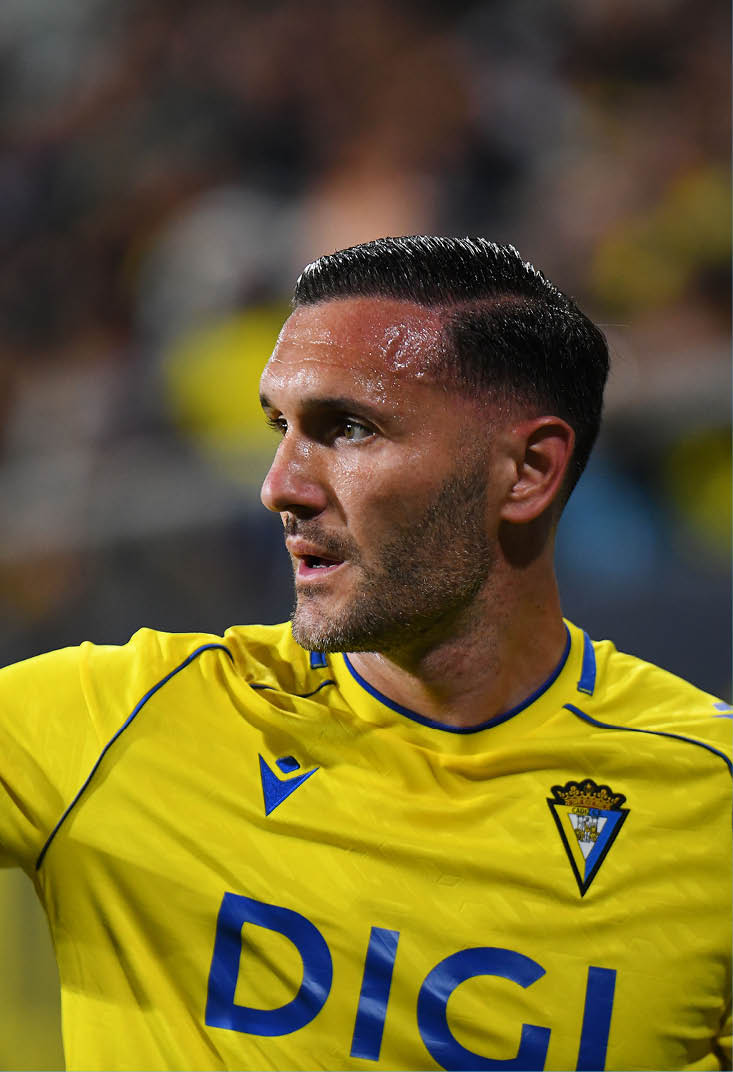A soccer player wearing a yellow shirt with the word Digic on it. Descripci n generada con IA