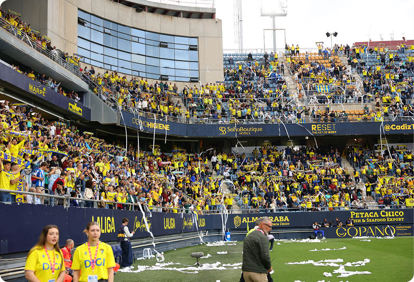 A large crowd of people are watching a game in a stadium. Descripci n generada con IA