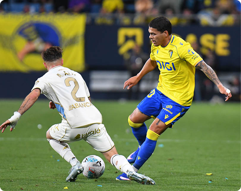 Two soccer players on a field. Descripci n generada con IA