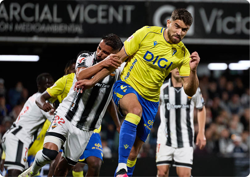 A soccer player in a yellow and blue uniform is about to kick the ball. Descripci n generada con IA