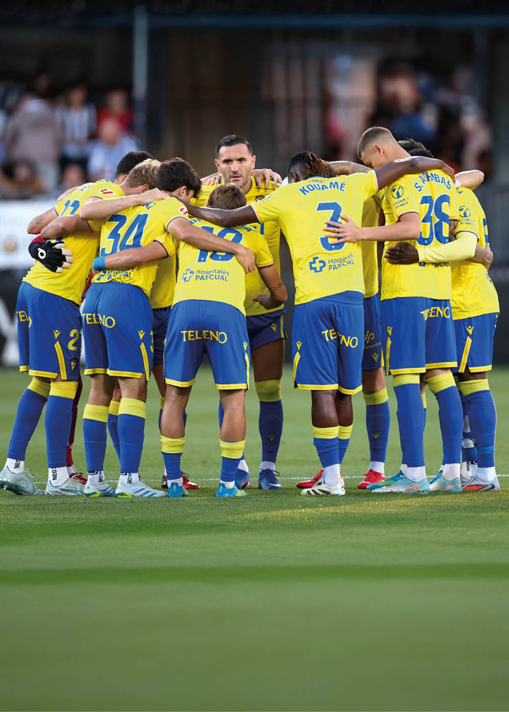A group of soccer players huddled together on the field. Descripci n generada con IA