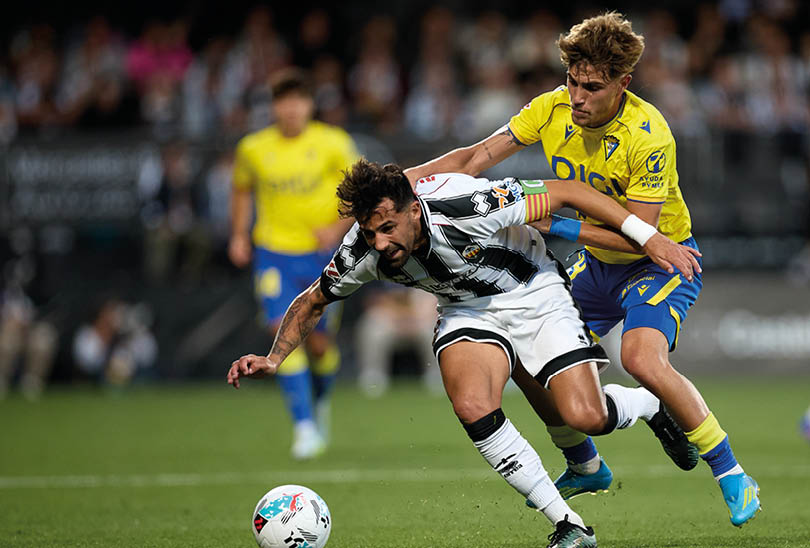 Two soccer players are fighting for the ball. Descripci n generada con IA