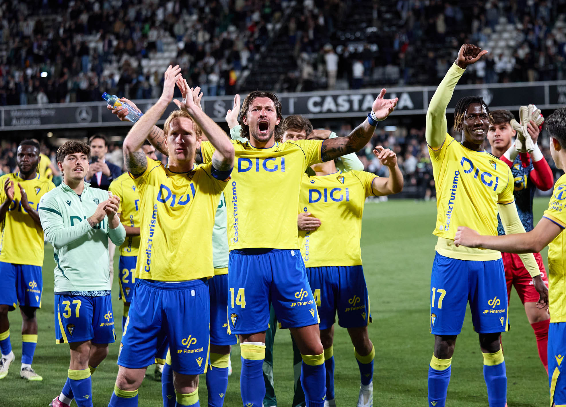 A group of soccer players in yellow and blue uniforms celebrating a victory. Descripci n generada con IA