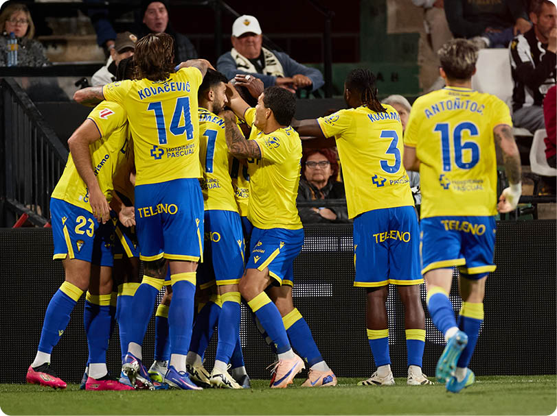 A group of soccer players celebrating a goal. Descripci n generada con IA