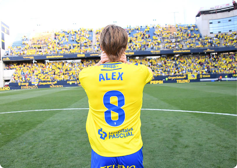 A soccer player in a yellow shirt is about to kick the ball. Descripci n generada con IA