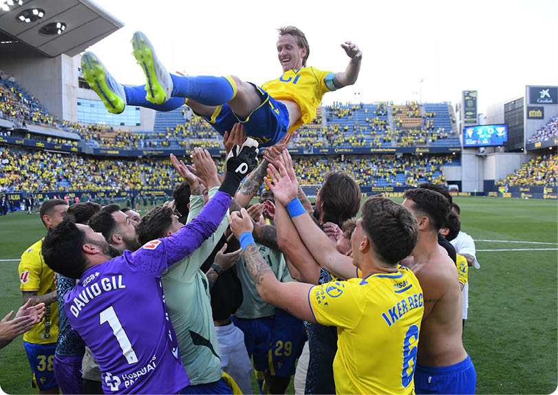 A soccer player in a yellow and blue uniform is about to kick the ball. Descripci n generada con IA