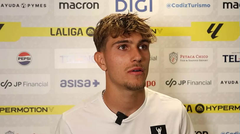 A man wearing a white shirt with a black logo. Descripci n generada con IA