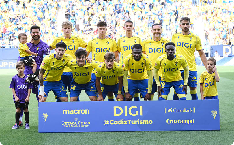 A group of young men in yellow and blue uniforms pose for a picture. Descripci n generada con IA