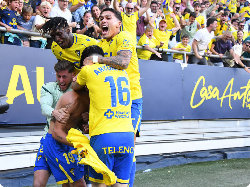 A group of men celebrating on a field. Descripci n generada con IA
