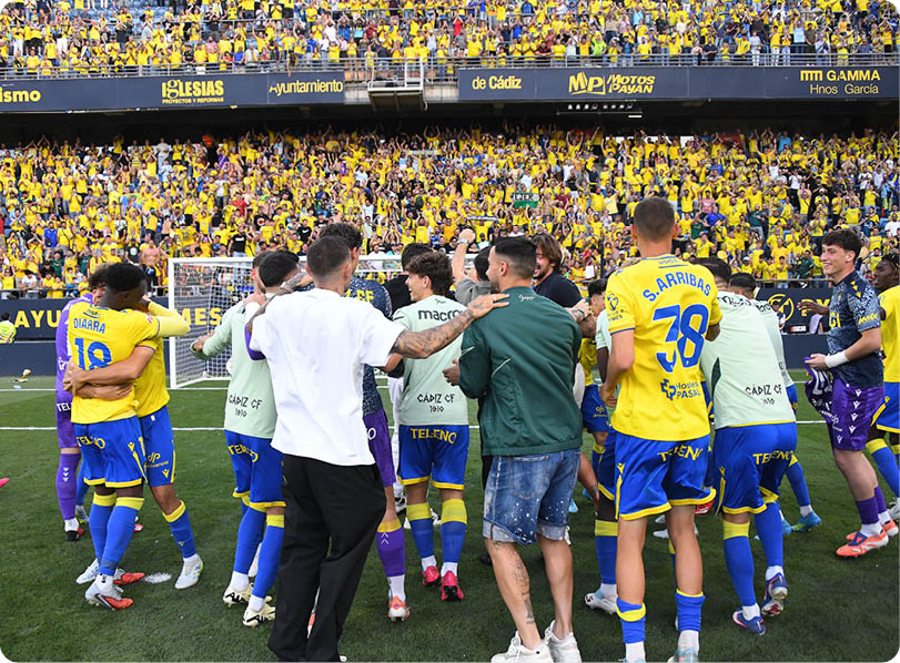 A group of men on a field, one of them wearing a green shirt. Descripci n generada con IA