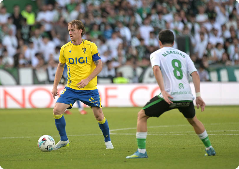 A soccer player in a yellow and blue uniform is about to kick the ball. Descripci n generada con IA